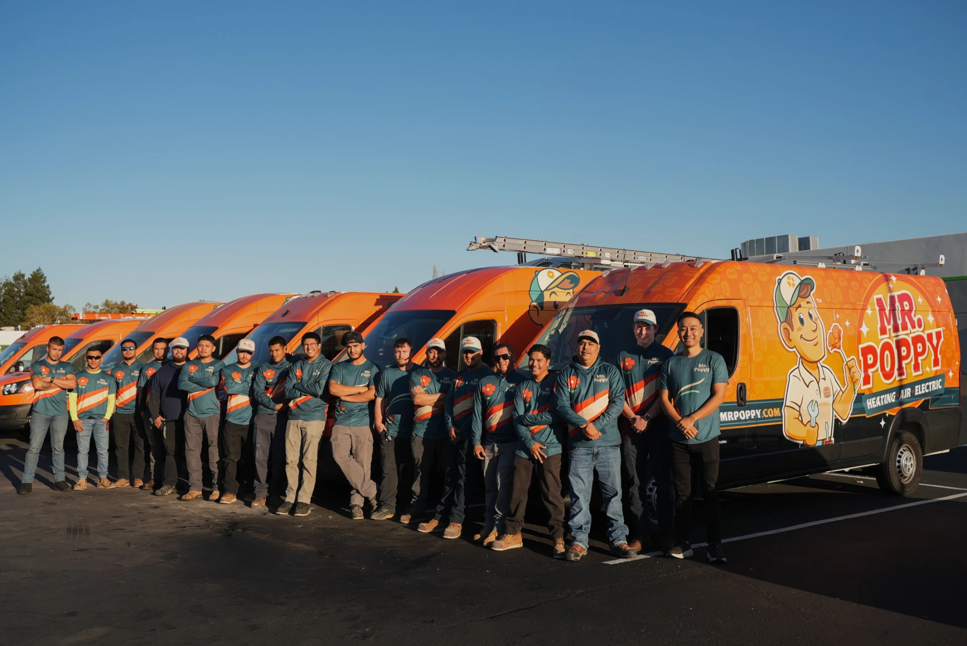 The Mr Poppy Electric team standing in front of the company fleet